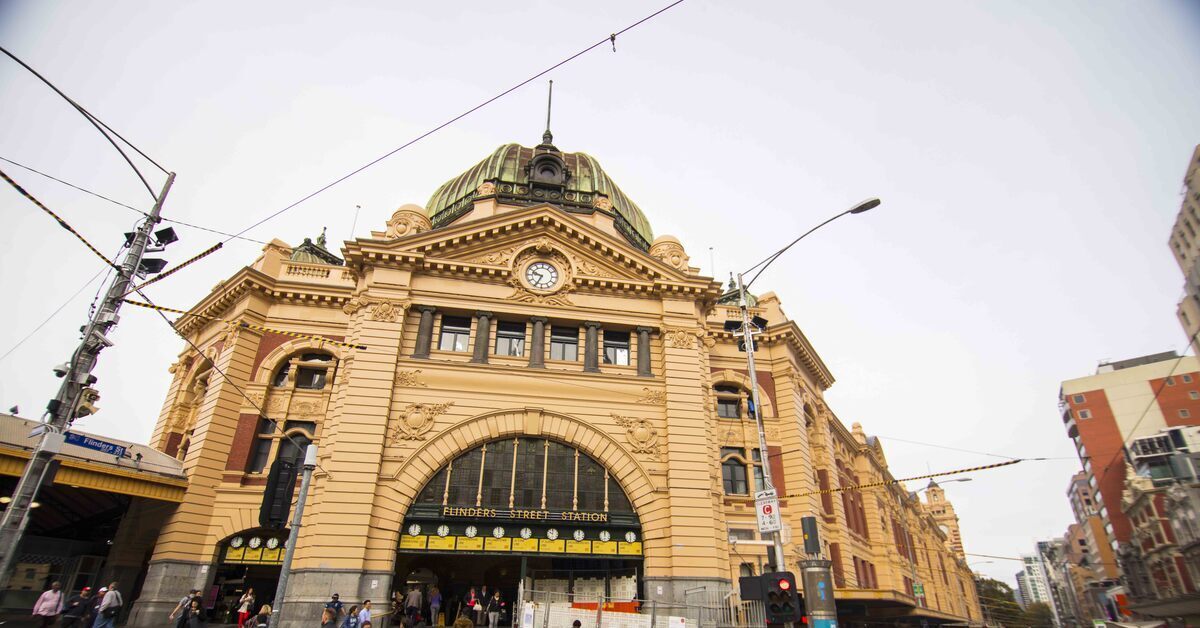 Street view of the iconic yellow heritage building and main entrance of Flinders Street Station.
